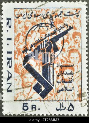 Vom Iran gedruckte, abgestempelte Briefmarke, die das Emblem der Volksmiliz zeigt, um 1981. Stockfoto