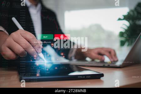 Geschäftsfrau oder Händler verwendet einen Stift, der auf ein Tablet zeigt, auf dem Handel und Investitionen an der Börse angezeigt werden. Stockfoto