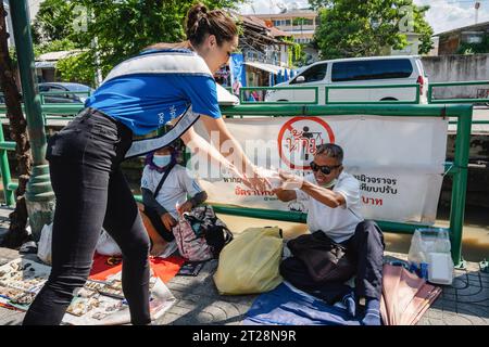 Bangkok, Thailand. Oktober 2023. Miss Thailand World 2023, Tharina Botes gibt Obdachlosen mit der Stiftung Bangkok Community Help in der Trok Sake Community in Bangkok kostenlose Kisten mit Lebensmitteln. Miss Thailand World 2023, Tharina Botes, gemischtes thailändisches und südafrikanisches Erbe, schlossen sich als Freiwillige einem Handout mit kostenlosen Mahlzeiten für Obdachlose und Menschen mit niedrigem Einkommen an, das von der Bangkok Community Help Foundation in Bangkok, Thailand, organisiert wurde. Quelle: SOPA Images Limited/Alamy Live News Stockfoto