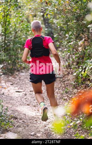 Frau, die Trailrunning im Wald übt Stockfoto
