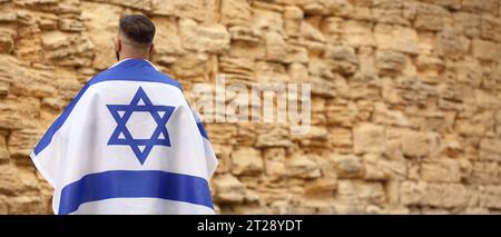 Mann mit der Flagge Israels in der Nähe der Klagemauer. Banner für Design Stockfoto