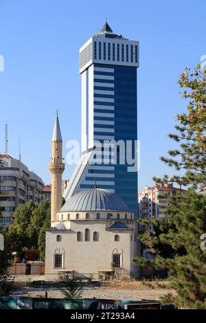 Ein mehrstöckiger Wolkenkratzer und eine kleine Moschee in Konya. Bera Holding Gebäude und Rathaus Moschee. Konya, Türkei. Stockfoto