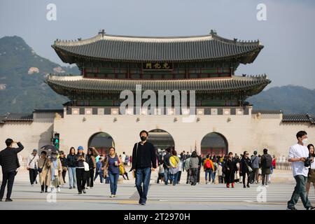 Seoul, Südkorea. Oktober 2023. Menschen überqueren eine Straße vor Gwanghwamun, dem größten Tor des Gyeongbokgung Palace in Seoul, Südkorea, 18. Oktober 2023. Das Gwanghwamun-Tor des Gyeongbokgung-Palastes wurde für die Öffentlichkeit geöffnet, nachdem es zum ersten Mal wieder in seinen ursprünglichen Zustand gebracht wurde. Quelle: Wang Yiliang/Xinhua/Alamy Live News Stockfoto