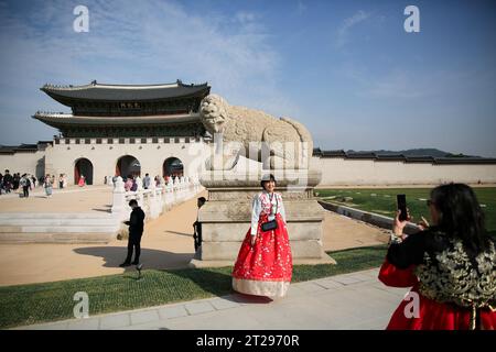 Seoul, Südkorea. Oktober 2023. Ein Tourist posiert für ein Foto vor Gwanghwamun, dem größten Tor des Gyeongbokgung Palace in Seoul, Südkorea, 18. Oktober 2023. Das Gwanghwamun-Tor des Gyeongbokgung-Palastes wurde für die Öffentlichkeit geöffnet, nachdem es zum ersten Mal wieder in seinen ursprünglichen Zustand gebracht wurde. Quelle: Wang Yiliang/Xinhua/Alamy Live News Stockfoto