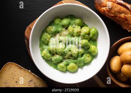 Food Concept Spot Focus hausgemachte cremige Pesto Gnocchi auf schwarzem Hintergrund mit Kopierraum Stockfoto