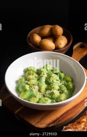 Food Concept Spot Focus hausgemachte cremige Pesto Gnocchi auf schwarzem Hintergrund mit Kopierraum Stockfoto