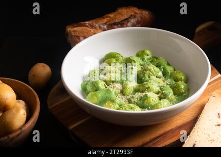 Food Concept Spot Focus hausgemachte cremige Pesto Gnocchi auf schwarzem Hintergrund mit Kopierraum Stockfoto