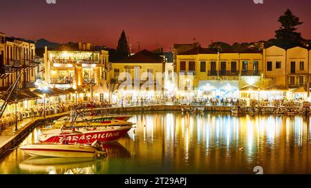 Venezianischer Hafen von Rethimnon, Abendfoto, roter Himmel, beleuchtete Häuser, Restaurants, roter Himmel, Boote, Rethimnon, Kreta, Griechenland Stockfoto