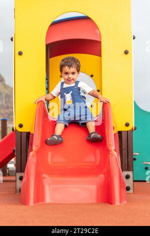 Baby spielt auf einem Spielplatz, der im Sommer Spaß hat, Park für kleine Kinder von einem bis drei Jahren Stockfoto