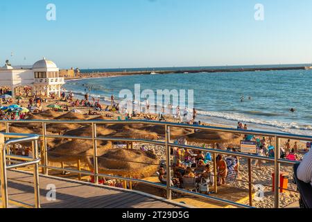 Badegäste am Strand von La Caleta im Sommer Sonnenuntergang der Stadt Cadiz. Andalusien Stockfoto