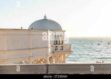 Maurisches weißes Gebäude am Strand von La Caleta in der Stadt Cadiz bei Sonnenuntergang. Andalusien Stockfoto