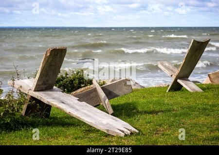 Holzstühle stehen auf einer Düne mit Blick auf das Meer Stockfoto