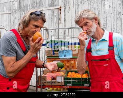 Lieferung im Bio-Handel, Männer auf Wagen vor dem Lager, Qualitätsprüfung, Geruch von Obst, Lieferung Einzelhandel und Transport, Deutschland Stockfoto