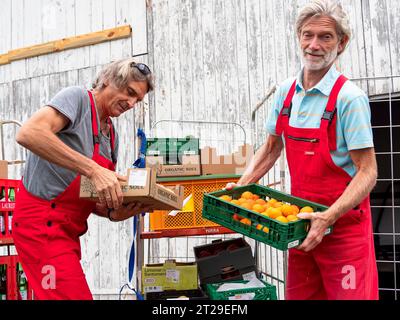 Lieferung im Bio-Handel, Männer Entladewagen vor dem Lager, Bio-Obstkisten mit Mandarinen, Versorgung Einzelhandel, Deutschland Stockfoto