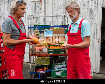 Lieferung im Öko-Handel, Männer auf Trolleys vor dem Lager, Qualitätsprüfung, Lieferung Einzelhandel und Transport, Deutschland Stockfoto