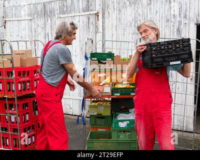 Lieferung im Bio-Handel, Männer Entladewagen vor dem Lager, Bio-Obstboxen, Versorgung Einzelhandel, Deutschland Stockfoto