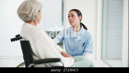 Arzt, Rollstuhl und eine Krankenschwester, die mit einem älteren Patienten mit Behinderung in einer Klinik spricht. Gesundheit, Ruhestand und Unterstützung bei einer Frau Stockfoto