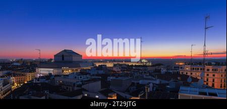 Panoramablick auf die Dächer von Madrids Altstadt bei Sonnenuntergang mit dem Königlichen Theater und dem Königlichen Palast im Hintergrund. Stockfoto