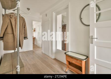 Innenseite des Flurs mit Garderobe und weißen Türen, die zu verschiedenen Zimmern im zeitgenössischen Haus führen Stockfoto