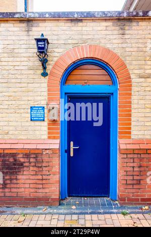 Die blaue Tür führt in die Untersuchungshaft der Polizeiwache in Staines-upon-Thames in Surrey, Großbritannien Stockfoto