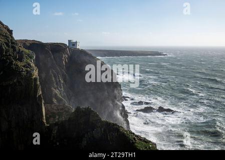 Elin's Tower eine Torheit am Rande der dramatischen Klippen in South Stack, Anglesey, Nordwales. Ein windiger Herbsttag mit Wellen, die gegen Felsen krachen. Stockfoto