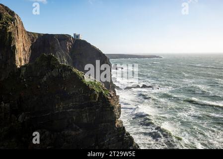 Elin's Tower eine Torheit am Rande der dramatischen Klippen in South Stack, Anglesey, Nordwales. Ein windiger Herbsttag mit Wellen, die gegen Felsen krachen. Stockfoto