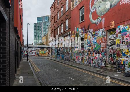 Graffiti und Flyer an den Mauern rund um die Brick Lane, London, sind zu einem absoluten Touristenziel geworden. Stockfoto