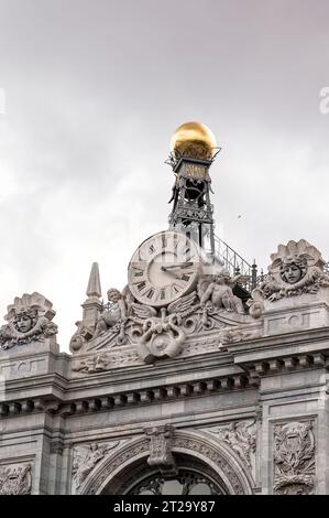 Detail der Fassade des Gebäudes der Bank of Spain mit seiner Uhr und einer goldenen Kugel Stockfoto