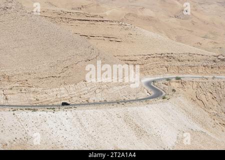 Ein einsamer Wagen auf dem Kings Highway überquert im August 2023 das Wüstengebiet Jordaniens nahe Wadi Al Mujib Stockfoto