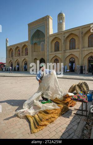 Namangan, Usbekistan - 16. Oktober 2023: Ein Besenhändler vor der Mullah Kirgisischen Madrasa in Namangan, Usbekistan. Stockfoto