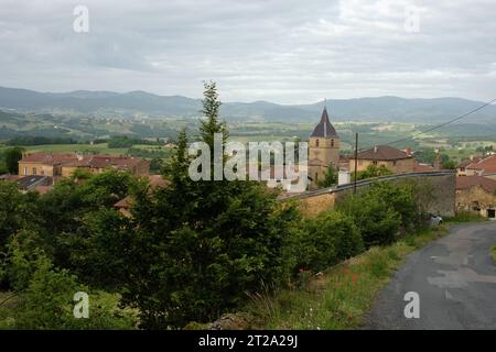 Das französische Dorf Bagnols von einer Straße oberhalb mit Blick an den goldenen Steinhäusern vorbei in das Tal der Bauernhöfe, Weinberge und französischen alpen Stockfoto