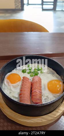 Rührei in einer Pfanne mit frittierten Würstchen in einem Restaurant Stockfoto