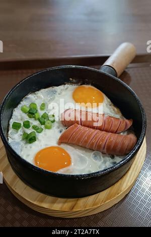 Rührei in einer Pfanne mit frittierten Würstchen in einem Restaurant Stockfoto