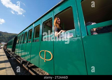 Passagier mit Blick aus dem Fenster des historischen Douro-Zuges, der zwischen Régua und Tua auf dem Fluss Douro, Portugal, Europa fährt Stockfoto