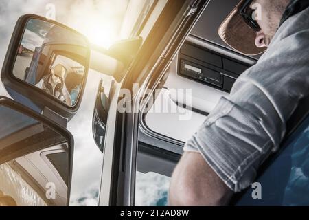 Mittelalter kaukasischer Semi-Truck-Fahrer in der Fahrzeugkabine Nahaufnahme Stockfoto