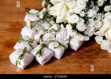 Dekorative Hochzeitsbonbons, wunderschöne gut verheiratete Schokolade verpackt und mit grüner Schleife auf Holztisch Stockfoto