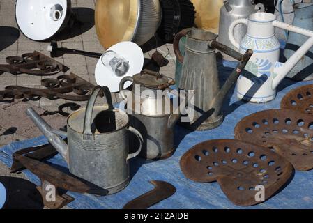 Vintage-Gießkannen, Sammlerstücke oder Sammlerstücke, Vintage-Lampen und alte Traktorsitze am Marktstand, Antiquitätenmarkt oder Brocante Provence Frankreich Stockfoto