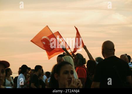 Izmir, Türkei, 9. September 2023, bei Sonnenuntergängen stehen vier Personen vereint und schwenken die türkische Flagge vor dem Hintergrund eines lebendigen Sonnenunterganghimmels Stockfoto