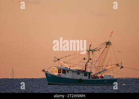 Isle Of Palms, Usa. Oktober 2023. Ein Garnelentrawler schleppt Netze bei Sonnenaufgang entlang der Atlantikküste am 18. Oktober 2023 in Isle of Palms, South Carolina. Garnelenfischerei ist ein traditioneller Wirtschaftszweig im Niederland, leidet jedoch unter extremer Hitze und den hohen Kosten für Dieselkraftstoff, die den Fang reduzieren und dazu führen, dass Garnelen ihre Aktivitäten einstellen. Quelle: Richard Ellis/Richard Ellis/Alamy Live News Stockfoto