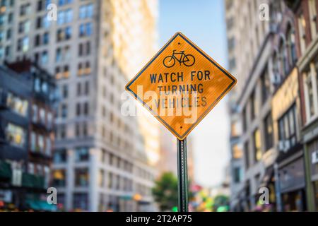 Ein Warnschild für Radfahrer, „Acht auf Wendefahrzeuge“, auf einer Straße in New York. Stockfoto