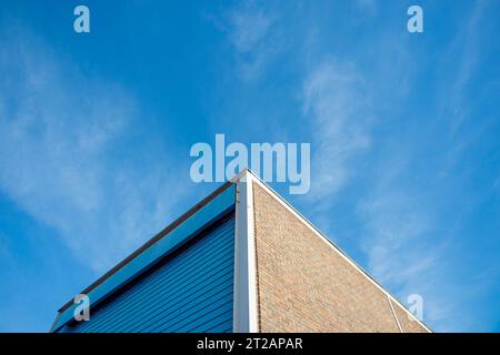 Lagereinheit für den Industriebau mit Rolltor vor blauem Himmel Stockfoto