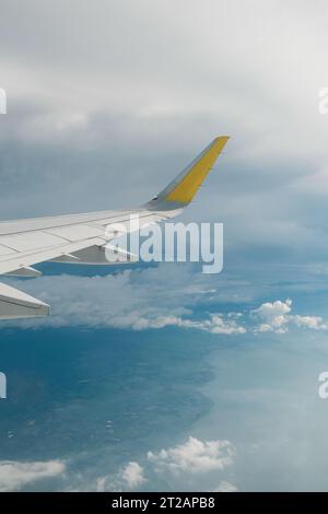 Ansicht des rechten Flügels vom Fenster des Flugzeugs, das in der Luft hochfliegt. Wolken im blauen Himmel. Flugzeug im Flug. Luftfahrt. Hintergrund von Flugreisen. Stockfoto