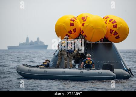NASA, Navy und Air Force üben die Artemis II-Astronauten-Bergung während der URT-10 im Pazifischen Ozean vor San Diego. Navy Taucher betreten den Orion Crew Module Test Artikel, um die Extraktion auf eine aufblasbare Plattform zu simulieren, bevor der Hubschrauber auf das Bergungsschiff gebracht wird. Stockfoto