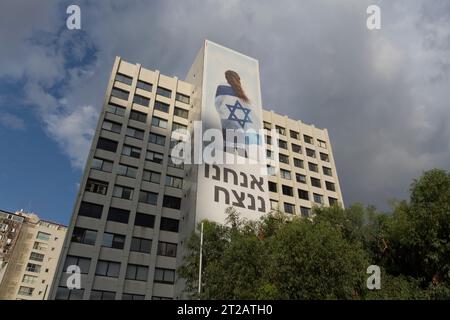 Bürogebäude mit großen Plakaten mit den Aufschriften „Wir werden gewinnen“ und „gemeinsam gewinnen“ am 16. Oktober 2023 in Tel Aviv, Israel. Während Israel sich auf die Invasion des Gazastreifens im Kampf gegen die Hamas vorbereitet, die militante palästinensische Gruppe, die am 7. Oktober einen tödlichen Angriff im Süden Israels gestartet hat Stockfoto