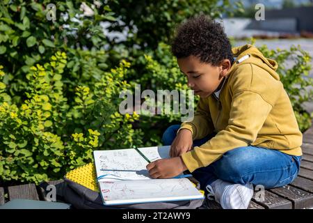 afroamerikanischer Schuljunge, der beim Hometask involviert ist Stockfoto
