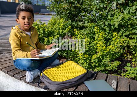 afroamerikanischer Schuljunge, der beim Hometask involviert ist Stockfoto