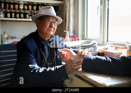 (231018) -- ORDOS, 18. Oktober 2023 (Xinhua) -- Mingan-erdeni fühlt den Puls eines Hirten in seinem Haus in Otog Banner von Ordos, nordchinesischer Autonomer Region Innere Mongolei, 16. Oktober 2023. Dorji ist ein 61-jähriger Hirte, der in Otog Banner lebt. Während der Herbstsaison gehört Dorjis tägliche Routine zum Hüten von Pferden und Ziegen. Er hat über 200 Arabas Kaschmirziegen, die eine solide wirtschaftliche Rendite bieten. In seiner Freizeit nimmt Dorji mit seinem 91-jährigen Vater Mingan-erdeni an einer lokalen kulturellen Aktivität namens „Nair“ Teil. Nair stammt aus der Yuan-Dynastie (1271–1368) und ist eine Form von Stockfoto