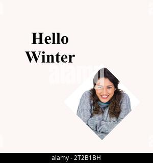 Hallo Wintertext auf weiß mit lächelnder birassischer Frau in warmem Pullover und Schal zur weihnachtszeit Stockfoto
