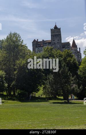 Mittelalterliches Schloss Bran (Castelul Bran), bekannt als Dracula's Castle, in Bran, Siebenbürgen, Rumänien, hinter grünen Bäumen und Rasen Stockfoto