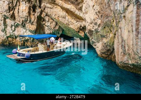 CAPRI, ITALIEN - 19. SEPTEMBER 2023: Touristen in einem Boot bewundern die Grüne Grotte auf Capri. Stockfoto